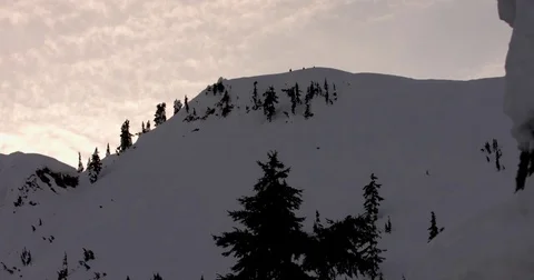 Sunset clouds moving over the snow capped mountains Stock Footage 77767077
