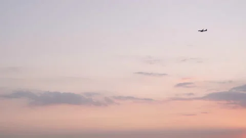 Sunset with clouds, orange sky, and an airplane passing by Vídeo Stock 143909103