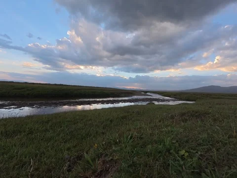 Sunset clouds over a steppe stream, Naryn Region, Kyrgyzstan Stock Footage 347242697