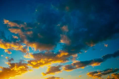 Sunset clouds. Partly cloudy sky at sunset background photo. Stock Photos