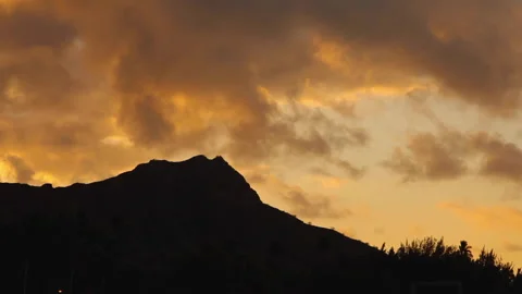 Sunset clouds passing by over a mountain Stock Footage 146949468
