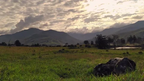 Sunset clouds with the sun setting behind the mountains. Timelapse 4k Stock Footage 159687072
