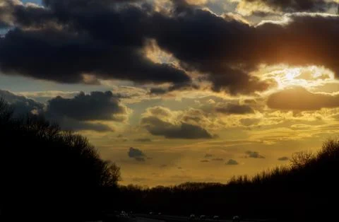 Sunset in clouds with sunrays over road to horizont Stock-Fotos