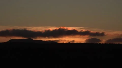 Sunset clouds timlapse over distant mountain Stock Footage 143746824
