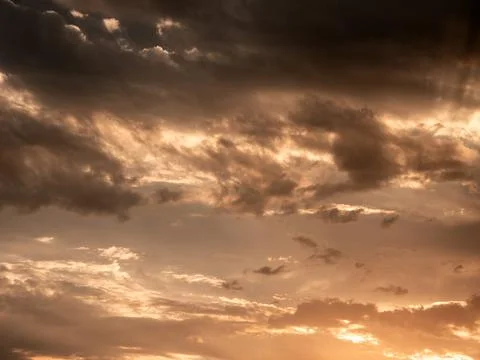 Sunset cloudscape with glowing orange and dark gray tones Stock Photos