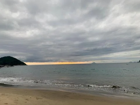 Sunset on a cloudy beach on the coast Stock Photos
