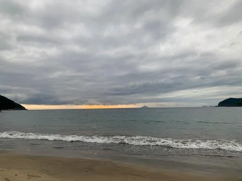 Sunset on a cloudy day on a beach on the north coast Stock Photos