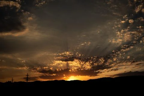 Sunset on a cloudy day with sun rays Stock Photos