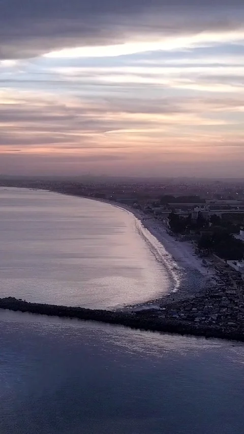 Sunset with cloudy sky over city with private houses and factories along beach Video stock 230671783