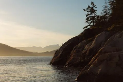 Sunset on coast with cliffs and mountains in background Stock Photos