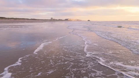 Sunset Coastal Glide with Distant Pier and Breaking Waves | FlyLens 4K Stockbeeldmateriaal 309452724