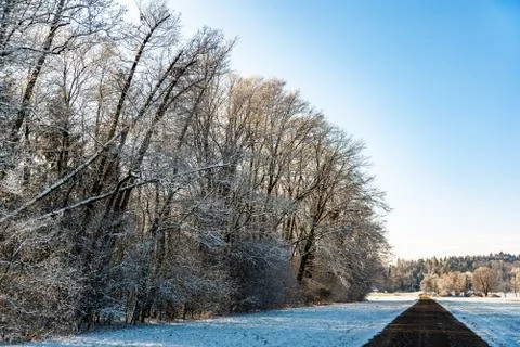 Sunset in a cold white winter day landscape. Road through rural area frosted  Stock Photos