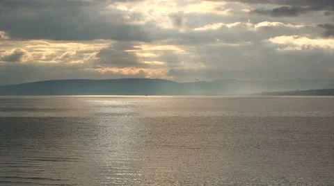 Sunset colored clouds and reflection on water with mountain silhouette Stock Footage 39986803