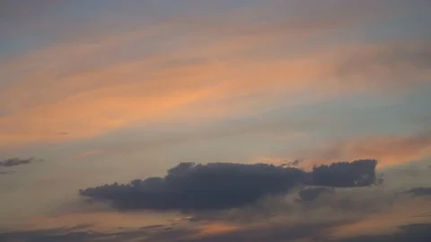 Sunset colored clouds move through the sky in a slow timelapse.   Stock Footage 161119350