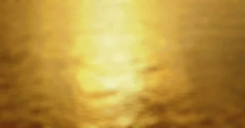 Sunset  - Completely defocused shot of a slightly wavy water surface Vídeo Stock 78647305