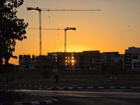 Sunset construction skyline with cranes Stock Photos