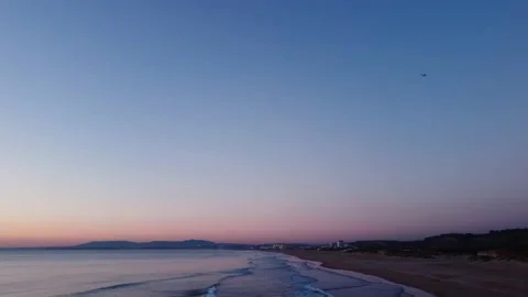 Sunset at Costa da Caparica beach with an airplane flying by Video stock 146102511