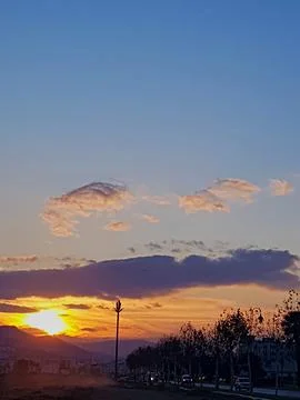 Sunset that creates a picturesque scene, where the warm hues of setting sun cast Stock Photos