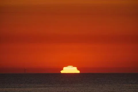 Sunset creating green flash over ocean horizon Stock Photos