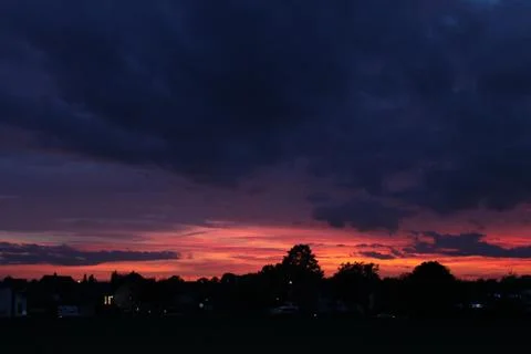 Sunset .Crimson sky. Night has come.Weak light of street lamps. Stock Photos