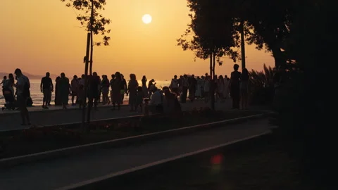 Sunset crowd along Zadar waterfront promenade Vídeo Stock 340625235