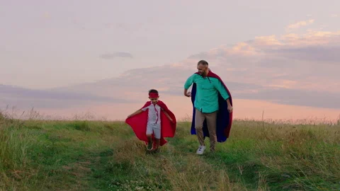 At sunset dad and his boy making a hard team together they wearing superheroes Stock Footage 170011525