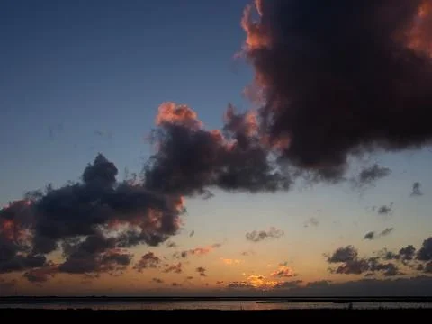Sunset with dark clouds and red sky Stock Photos