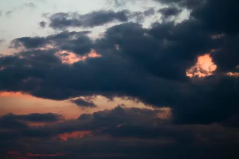 Sunset with dark clouds, in orange and purple shades 写真素材