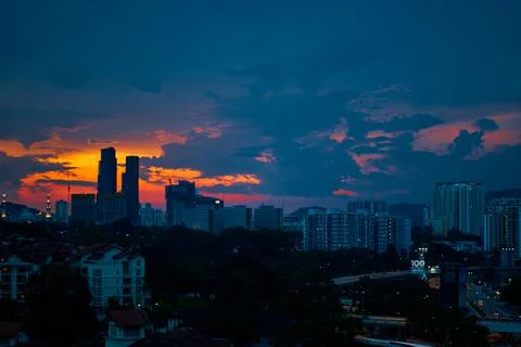 Sunset with dark rainy clouds over modern city Stock Photos