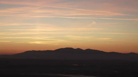 Sunset on a dark tuscan mountan with slow clouds Stock Footage 293775737