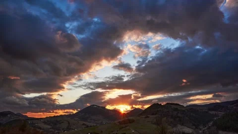 Sunset, dense colored clouds, rapid movement of clouds. Hilly rural spring Video stock 181623692