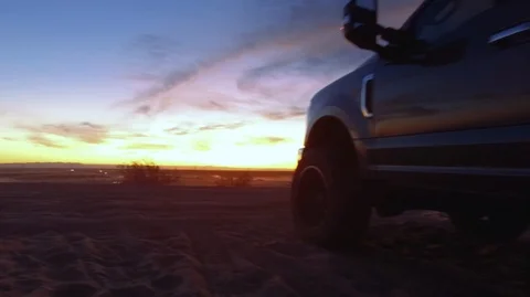 Sunset in the desert with dune buggies driving by Stock Footage 99158619