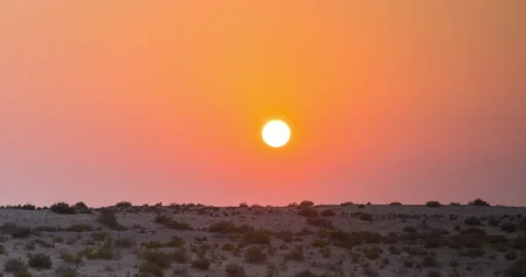 Sunset in desert, sun sets over the horizon or hill, orange sky, dusk Видео 131378368