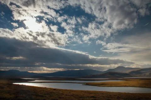 Sunset in the desert, the sun's rays Shine through the clouds. Ukok Plateau O Stock Photos