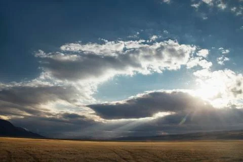 Sunset in the desert, the sun's rays Shine through the clouds. Ukok Plateau O Stock Photos