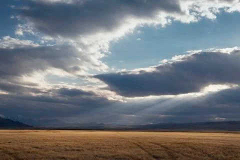 Sunset in the desert, the sun's rays Shine through the clouds. Ukok Plateau O Stock Photos