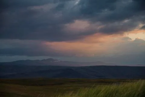 Sunset in the desert, the sun's rays Shine through the clouds. Ukok Plateau O Stock Photos