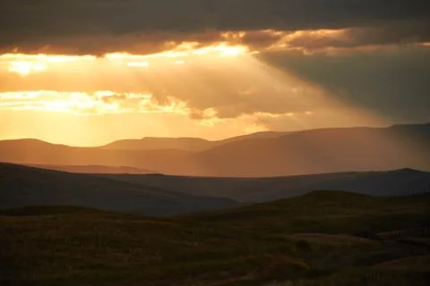 Sunset in the desert, the sun's rays Shine through the clouds. Ukok Plateau O Stock Photos
