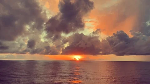 Sunset with Dramatic Clouds Over a Calm Ocean Stock Footage 338282473