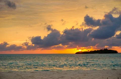 Sunset with dramatic clouds on the tropical beach. Panorama with two uninhabi Stock Photos