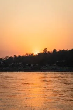 Sunset dramatic orange sky over river horizon at evening from flat angle 스톡 사진