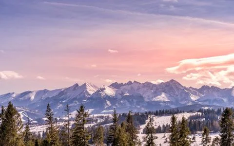 Sunset with dramatic sky and panoramic view on forest and snowy Tatra Mountai Stock Photos