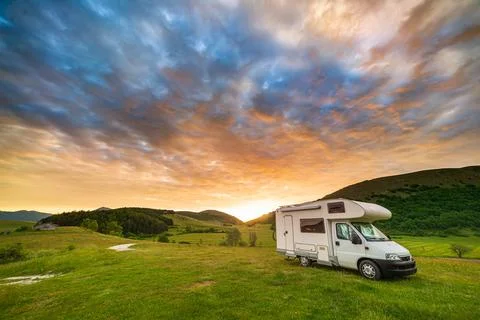 Sunset dramatic sky over camper van in Montelago highlands, Marche, Italy. Ep Stock Photos