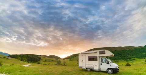 Sunset dramatic sky over camper van in Montelago highlands, Marche, Italy. Ep Stock Photos
