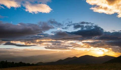 Sunset dramatic sky over Fabriano city, Marche, Italy. Sunbeams among clouds  Stock-Fotos