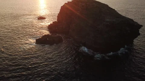 At sunset, the drone flies over a rock isolated from the seaside in France Stock Footage 164584761