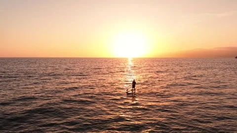 Sunset Drone Flight Toward Paddleboarder on Ocean in 4K Stock Footage 332327261