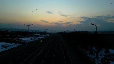 At sunset, a drone flying with crows over the road 動画素材 294822928