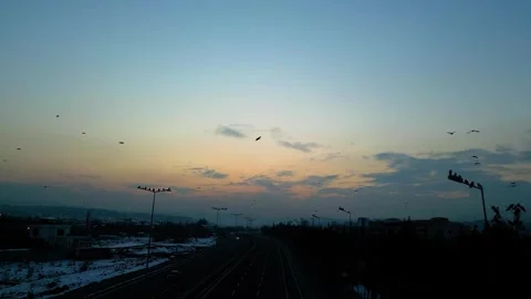 At sunset, a drone flying with crows over the road 動画素材 294823574