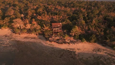 Sunset drone footage over secluded tropical beach with forest backdrop Stock Footage 321050100